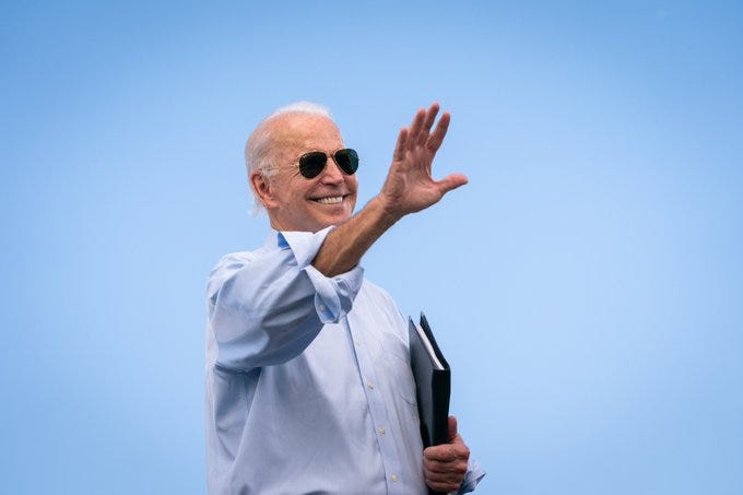 Joe Biden in aviators, waving.