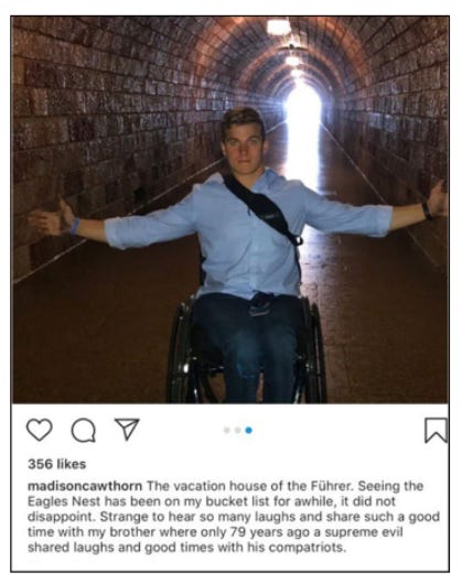 Madison Cawthorn is facing the camera, smiling with his arms outstretched, seated in a wheelchair.