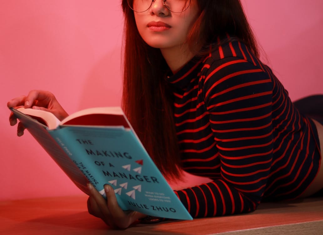 Free Woman in Striped Long Sleeve Shirt Holding a Book Stock Photo