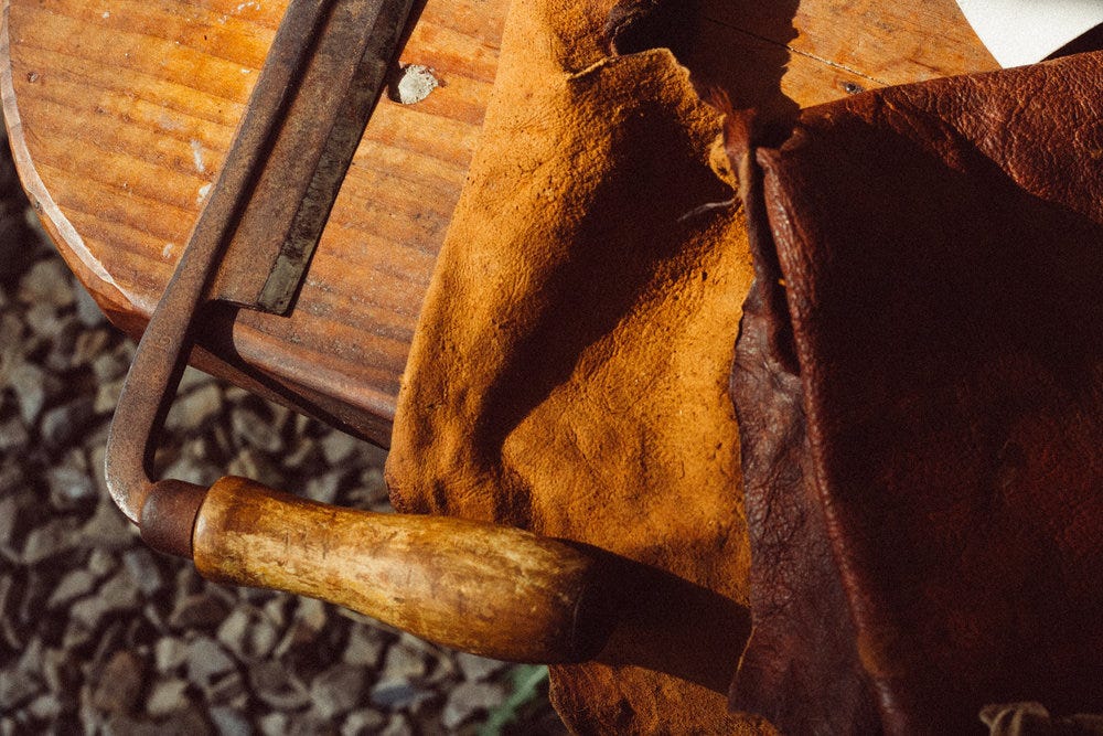 finished bark tanned leather and drawknife, one tool that can be used for harvesting bark for the tannin baths