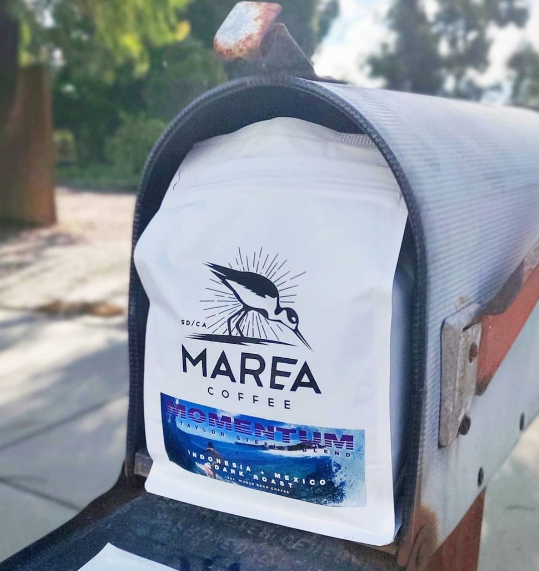 A bage of Marea Coffee filling up a mailbox.