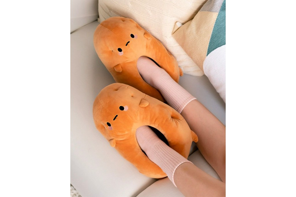 Feet inside of slippers shaped like cartoon potatoes 