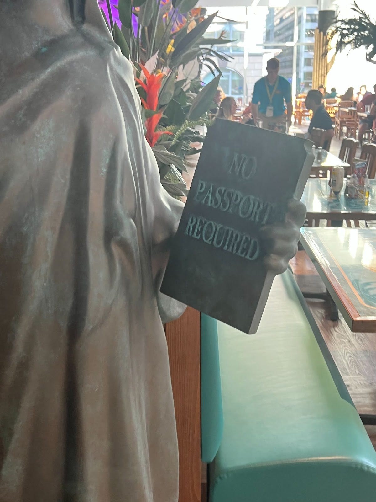 Cropped photo of fake Statue of Liberty in the restaurant with a tablet that says No Passport Required.