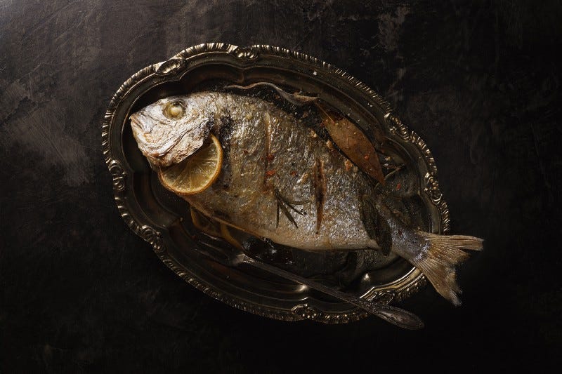 fish in a nice glass dish with an orange in its gill