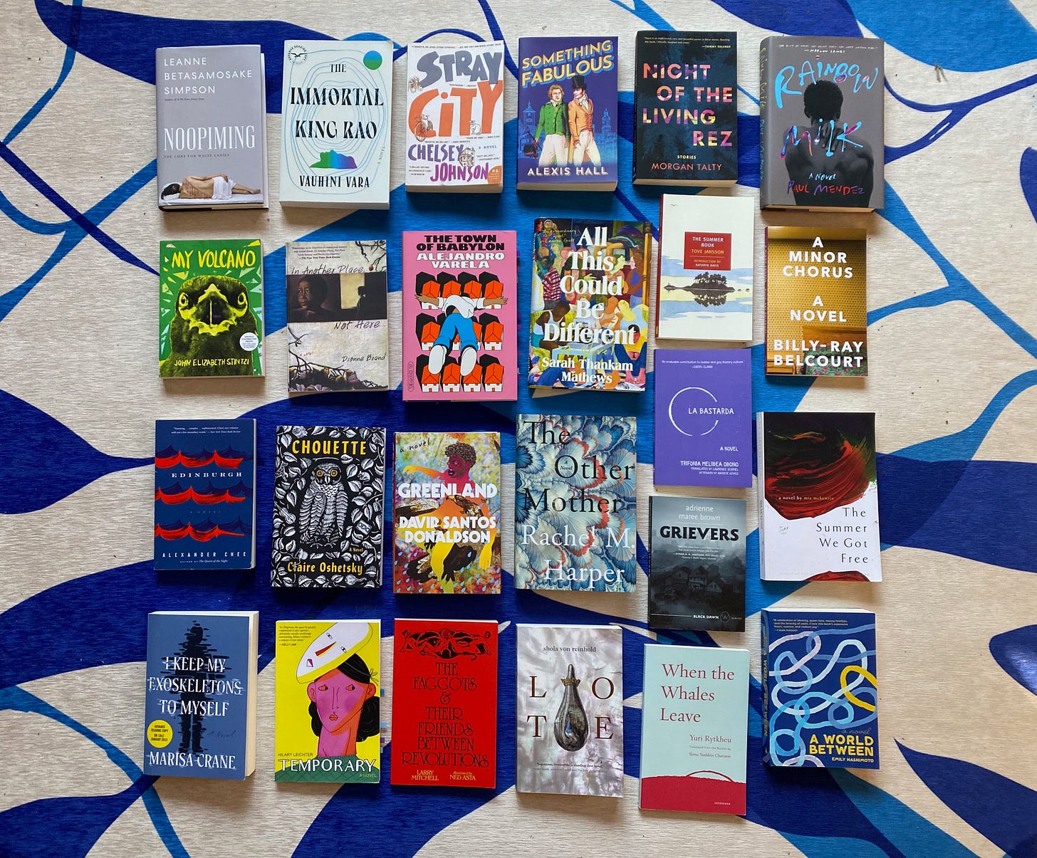 A selection of the listed books arranged in a grid on a blue and white rug.