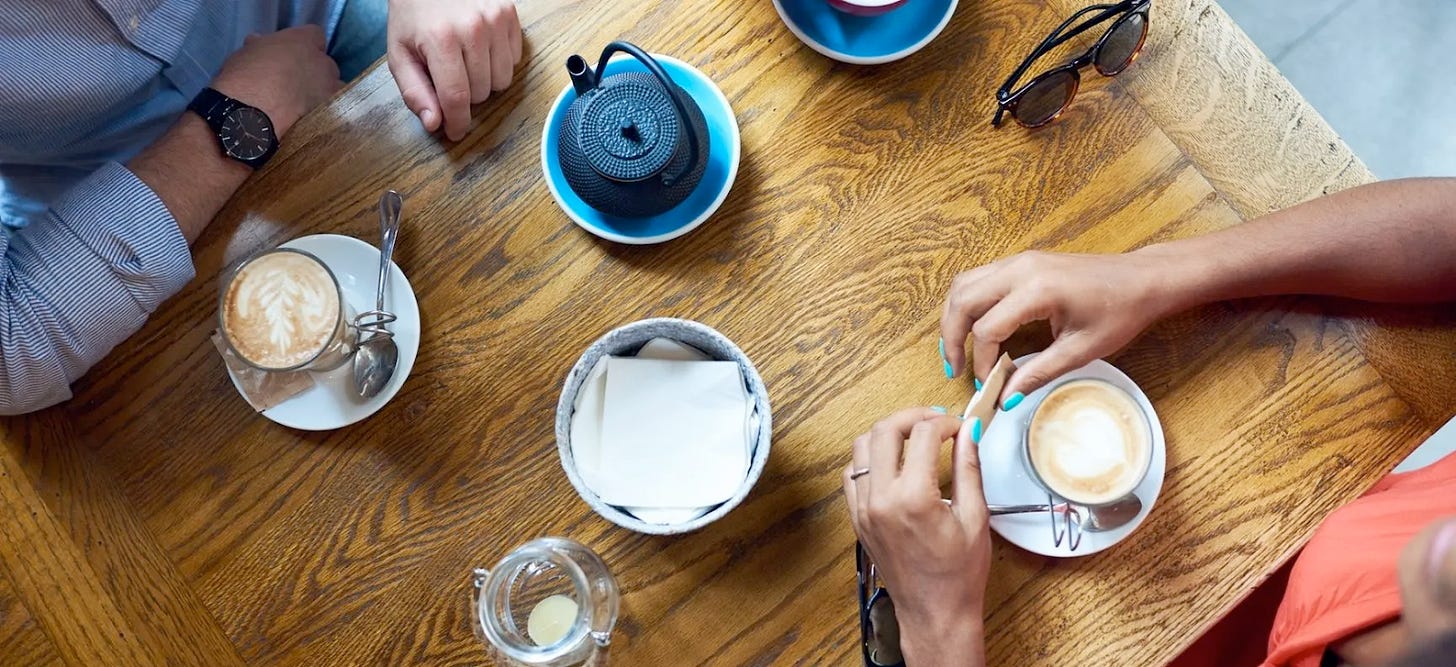 aerial photo of hands holding cups of coffee