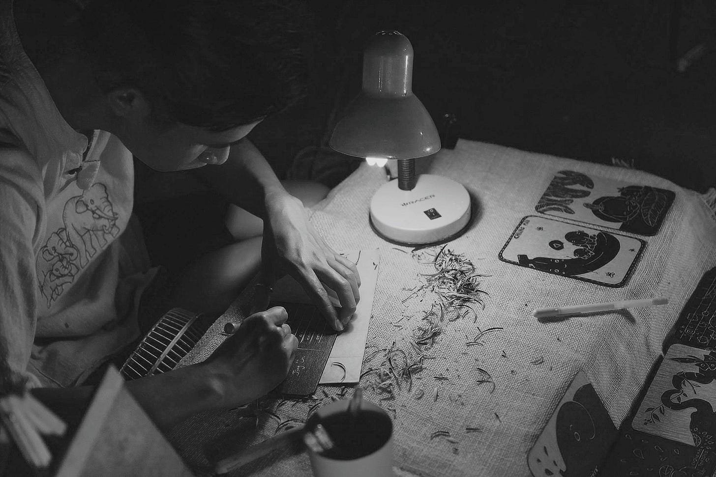 A man making Chinese crafts by table lamp for article about small business by Larry G. Maguire