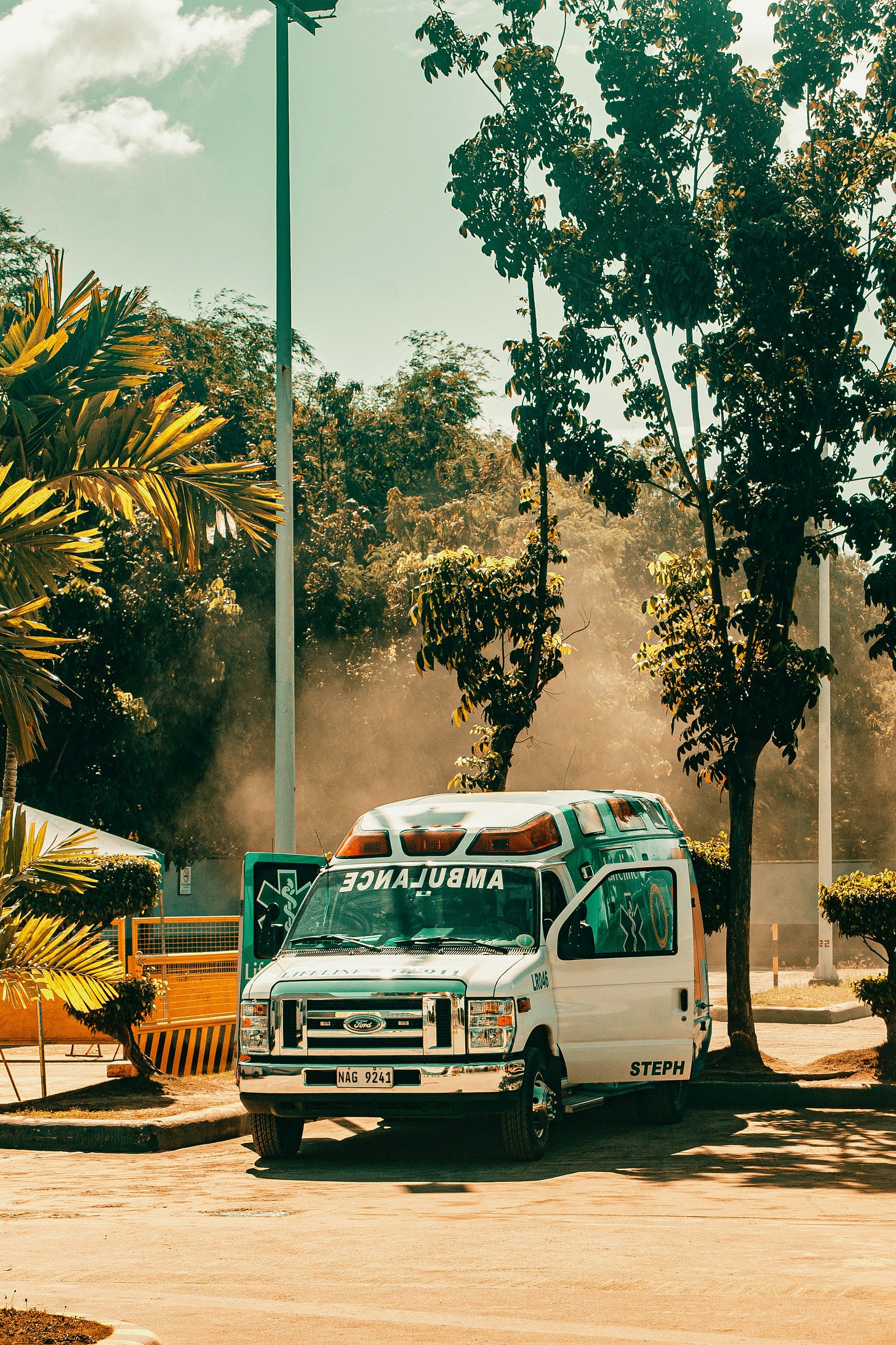 Ambulance parked beneath trees