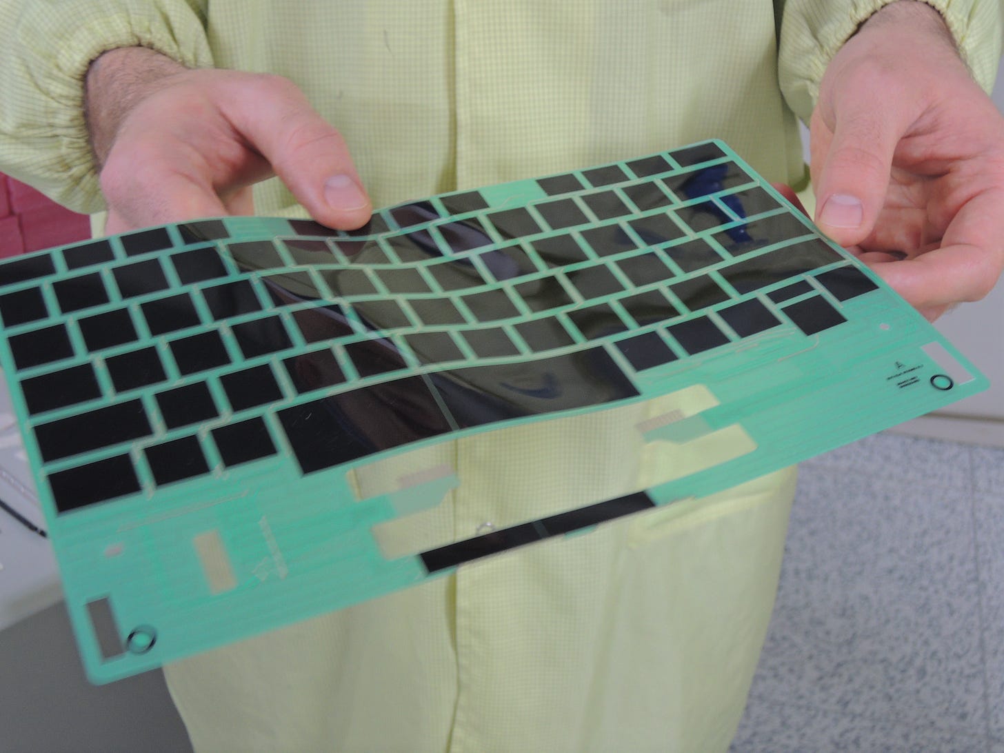 A person holding the touch layer of the Touch Cover. It is a very very thin and flexible piece of plastic with outlines for the keys.