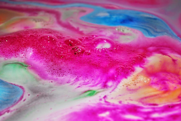 A rainbow of colour from a Lush bath bomb as it dissolves in water