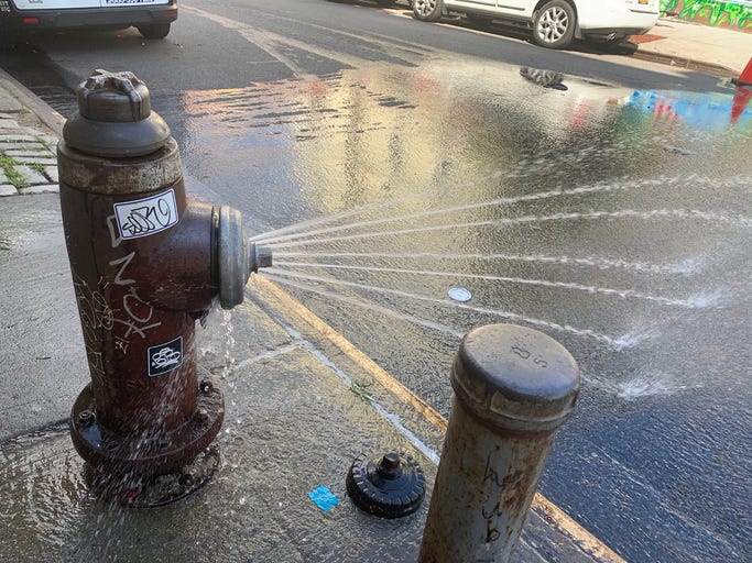 Open fire hydrant with graffiti on it
