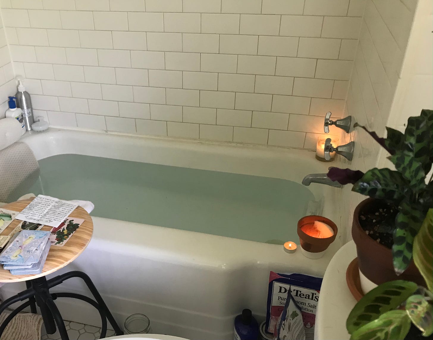 photo of a bath with tarot cards nearby and candles