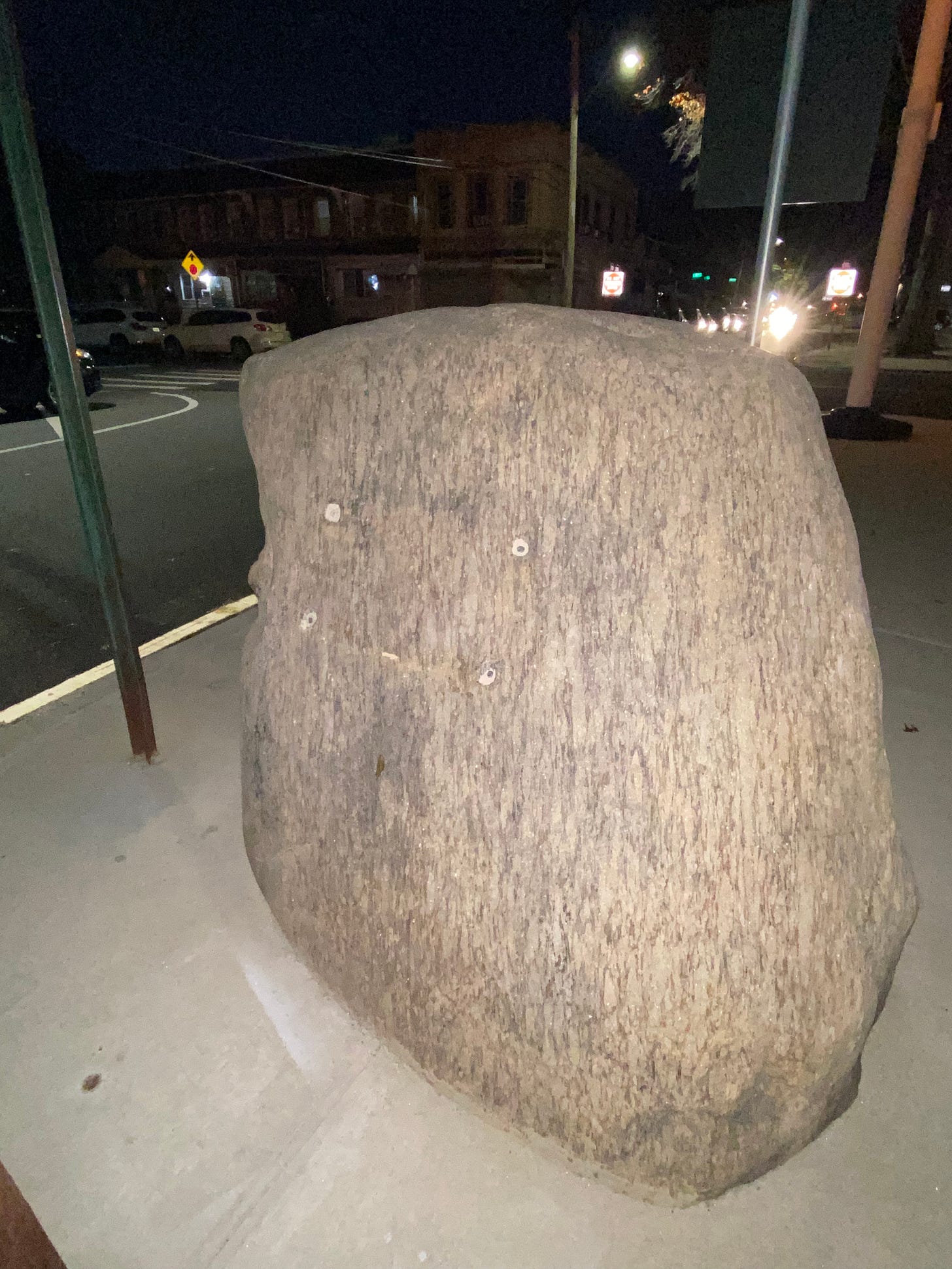 Image is a photograph of "the rock" of Whiting Square, illuminated by flash photography at night.