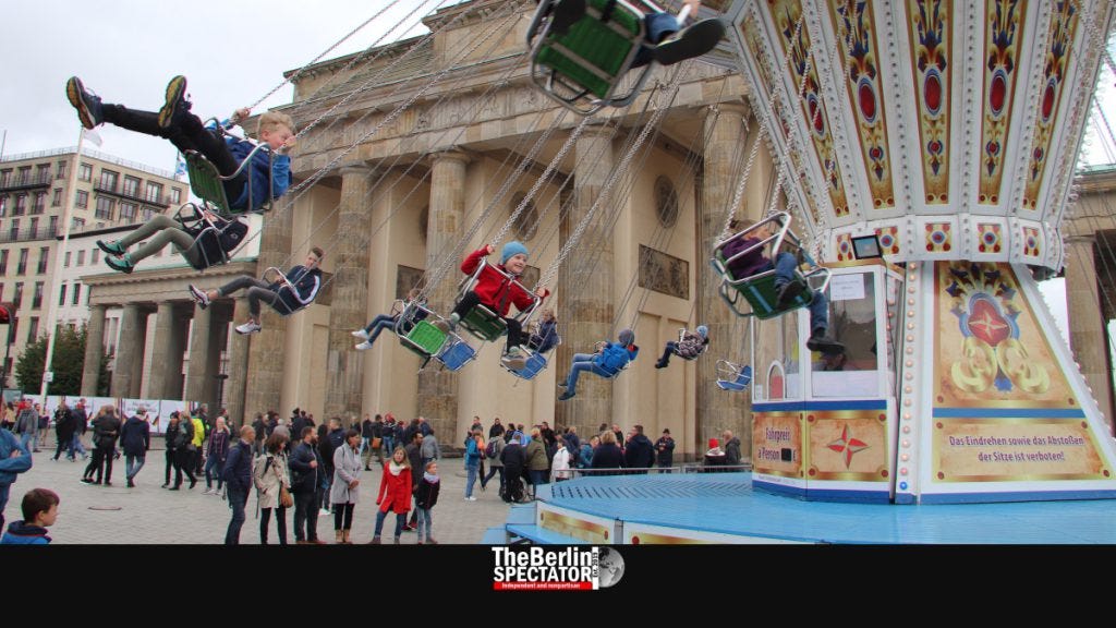 Kids are having fun on a merry-go-round at Brandenburg Gate.