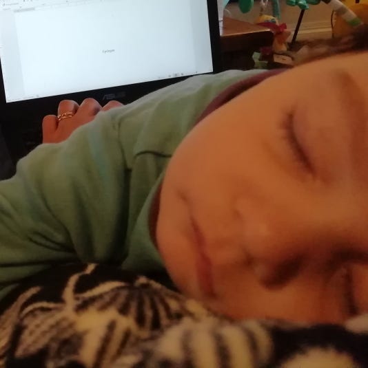 Photograph: A sleeping baby in the foreground, with a laptop in the background with the text Epilogue