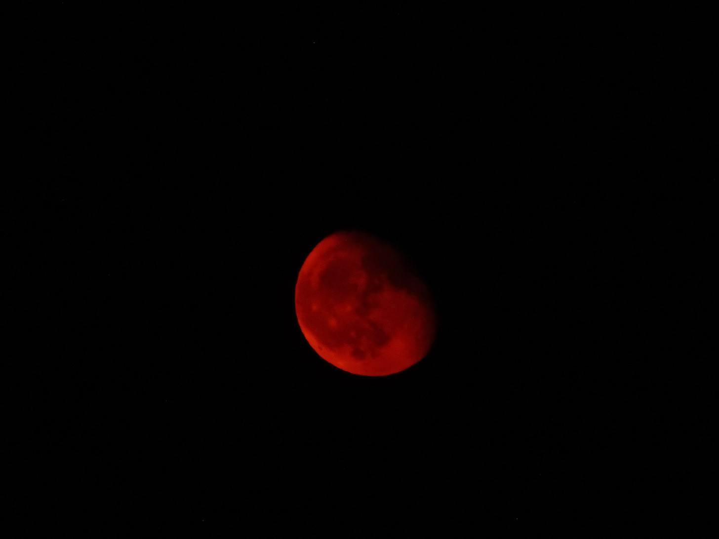 A blood red moon surrounded by black sky