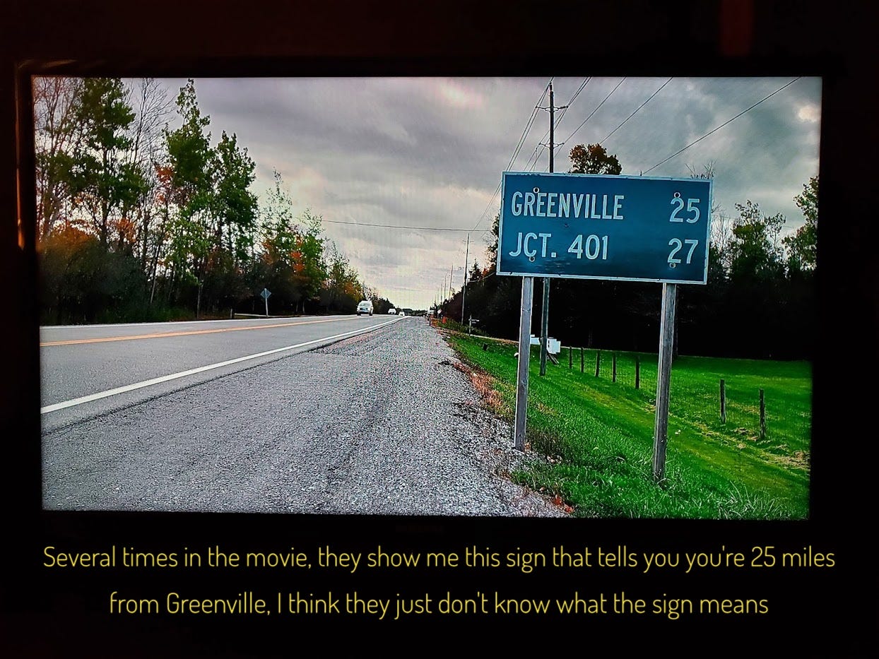A country road with a sign reading "GREENVILLE 25", captioned "several times in the movie, they show me this sign that tells you're you're 25 miles  from Greenville, I think they just don't know what the sign means"