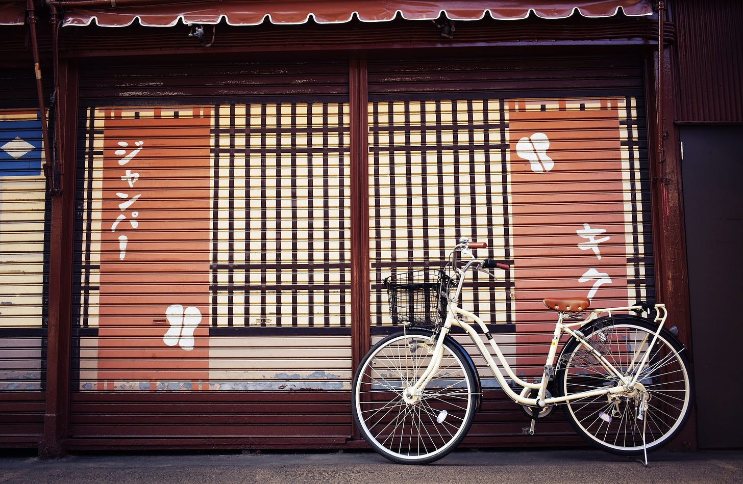 White bicycle in front of building with Japanese writing
