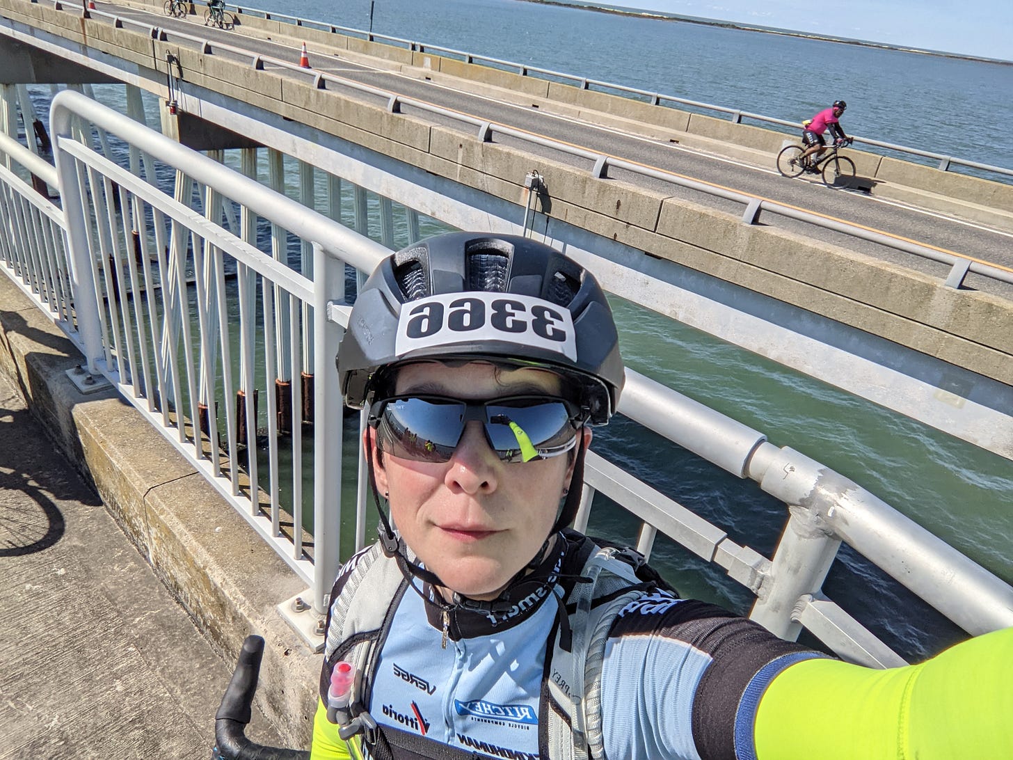 A bicyclist standing on a bridge