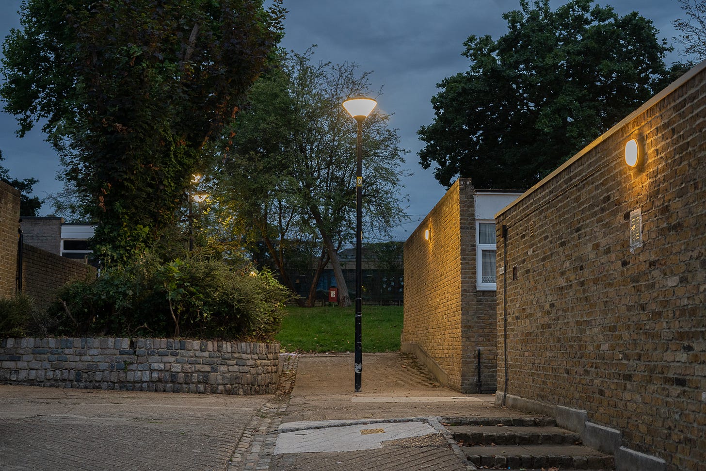 colour photo of lamppost framed by brick buildings and wall