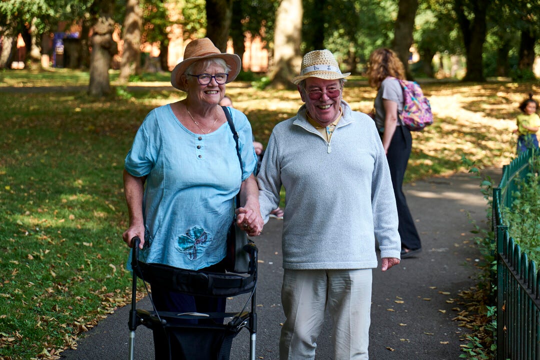 Older couple walking and smiling. 
