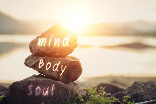 Three rocks with the words mind, body, soul. 