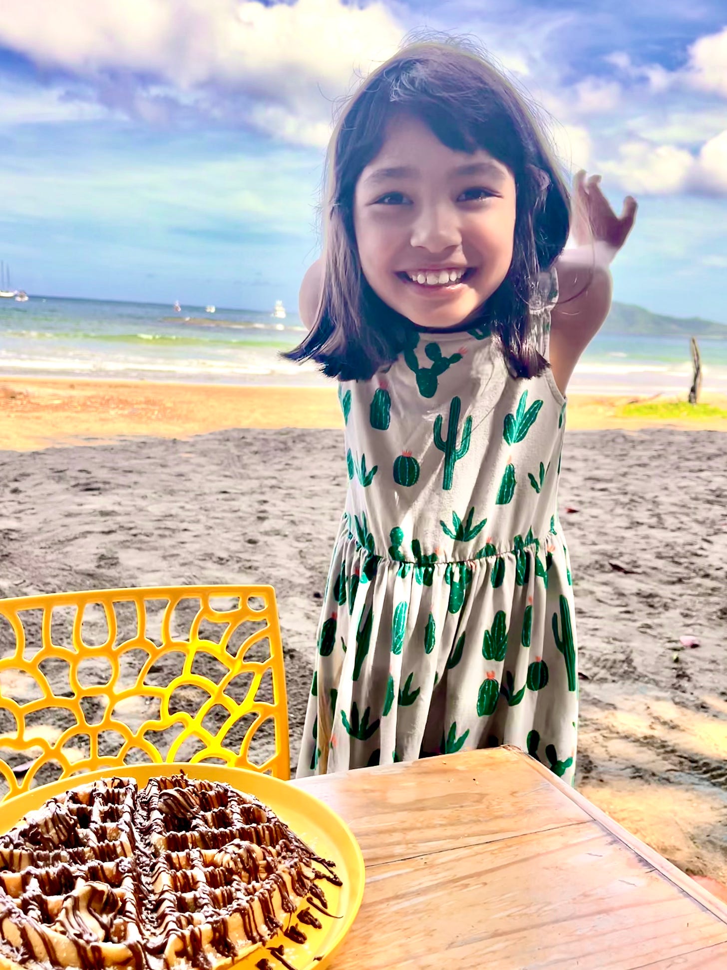 Girl on beach next to waffle on table