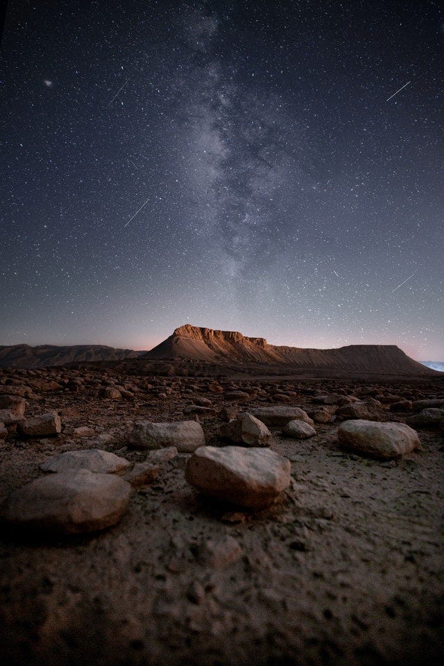 Rocky terrain at night against starry sky