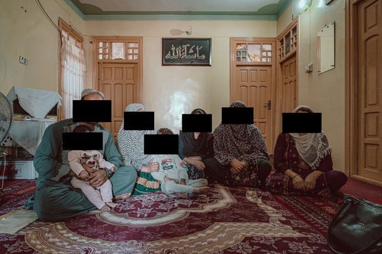 An Afghan family seen with his family. Tier faces are blacked out to protect their identities.