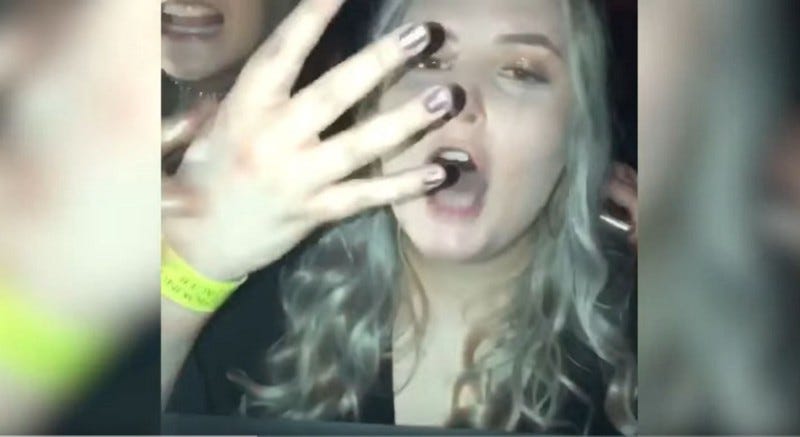 A very drunk woman holding up four fingers. Clip from a video where she is requesting these drinks from the DJ. Believe me, I’ve seen worse, at least she was polite.