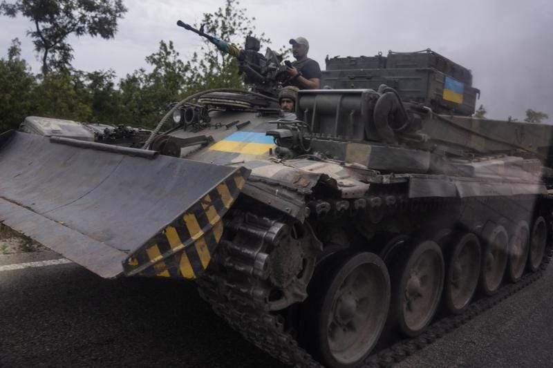FILE - Ukrainian soldiers ride a tank on a road, in Stupochky, Donetsk region, eastern Ukraine, Sunday, July 10, 2022.  Ukrainians living in the path of Russia's invasion in the besieged eastern Donetsk region are bracing themselves for the possibility that they will have to evacuate. (AP Photo/Nariman El-Mofty, File)