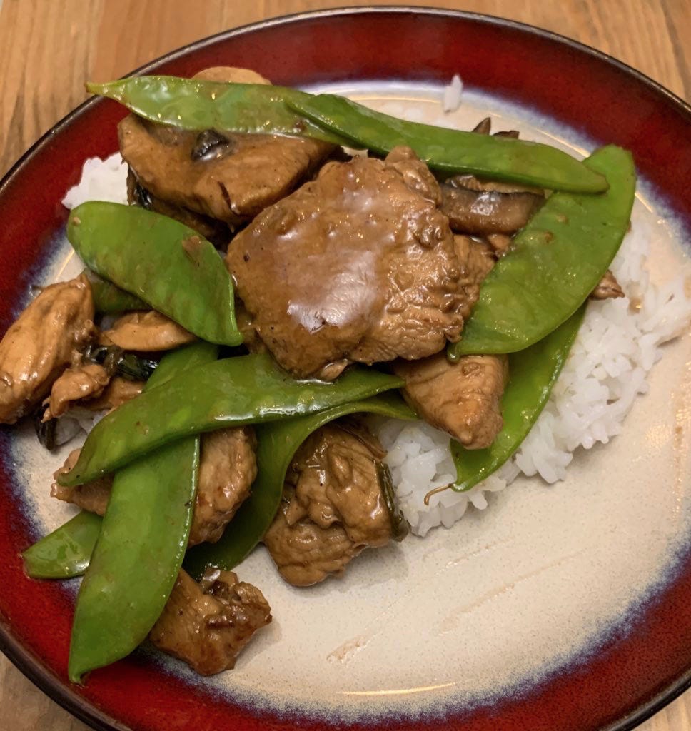 Image is a plate of chicken and snow peas on rice.
