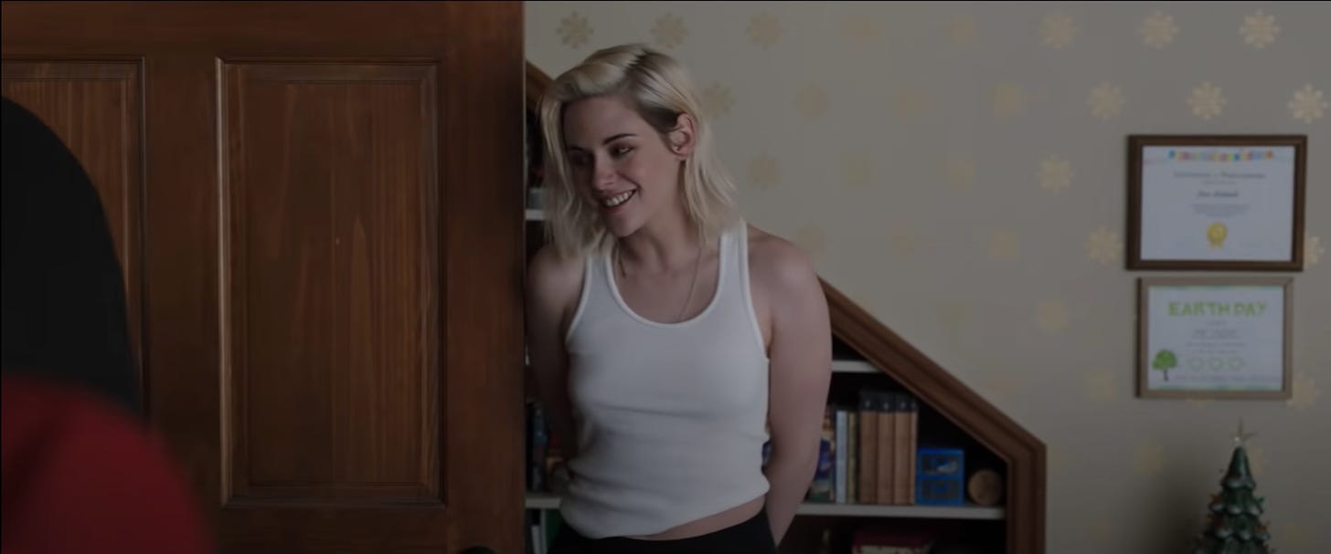 Kristen Stewart as Abby in a screenshot from Happiest Season. She is wearing a white singlet. 