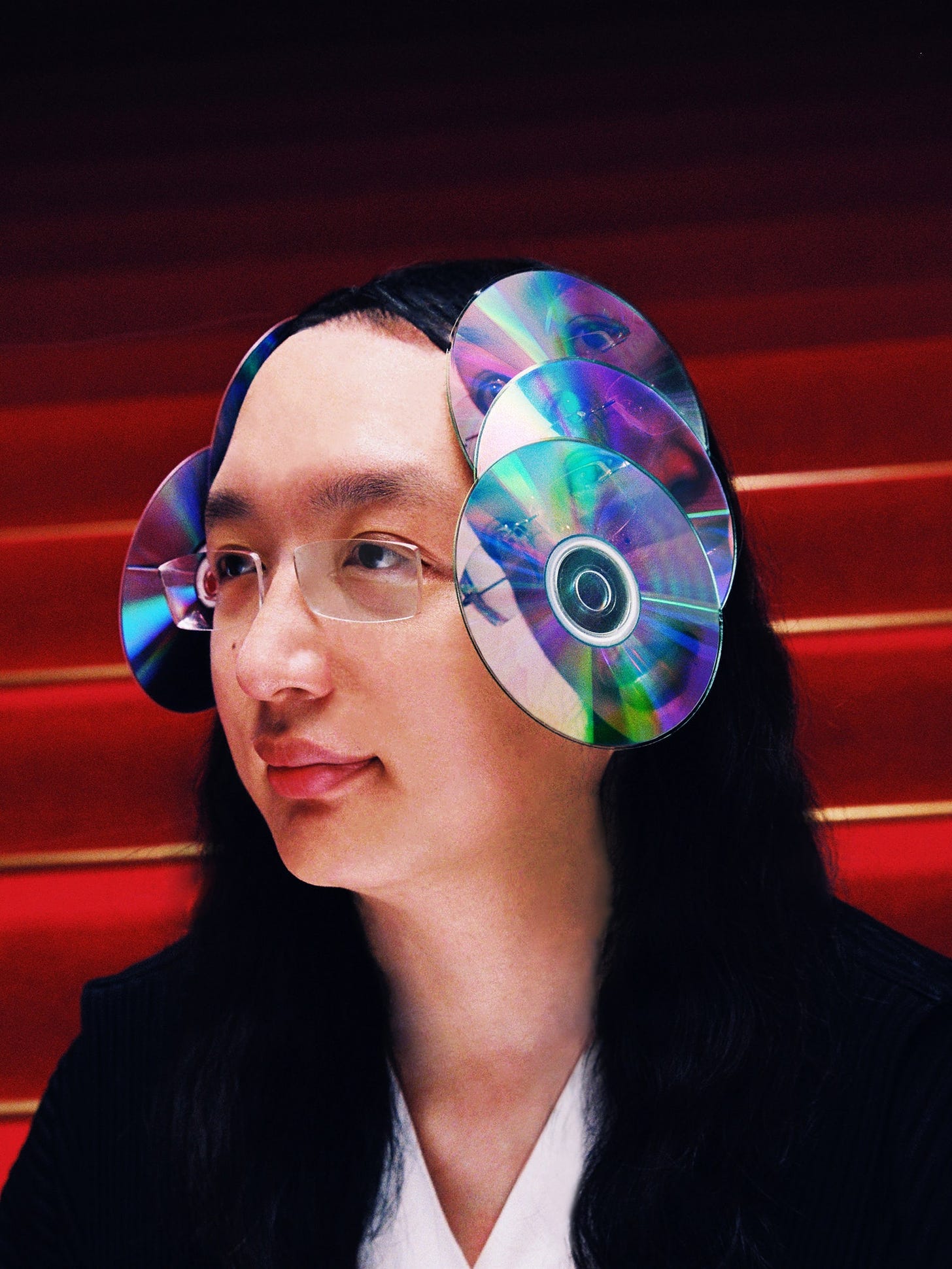 Audrey Tang with discs attached to her head with her reflection appearing in each disc