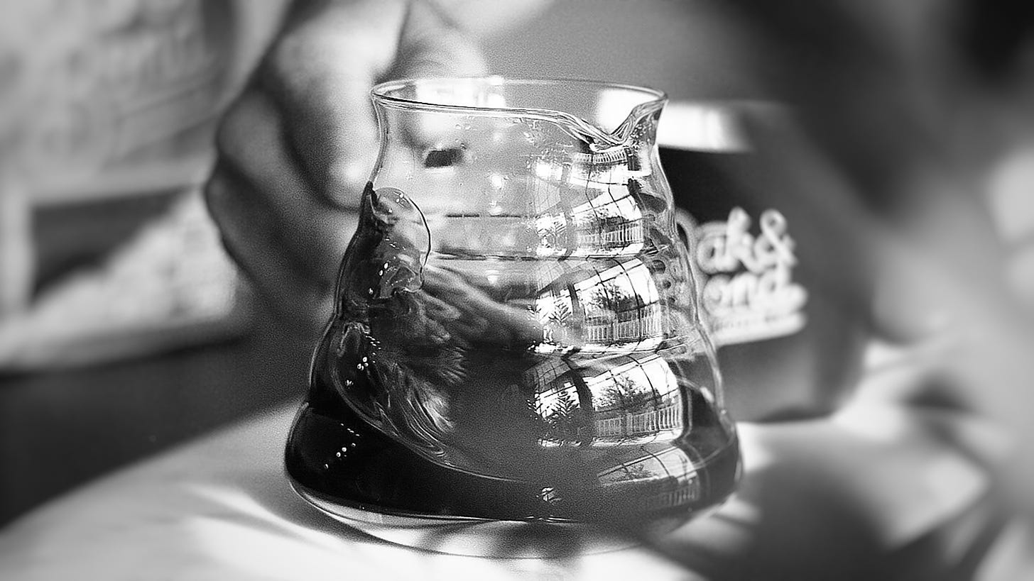 Close up of a Kalita Wave carafe being swirled with coffee inside