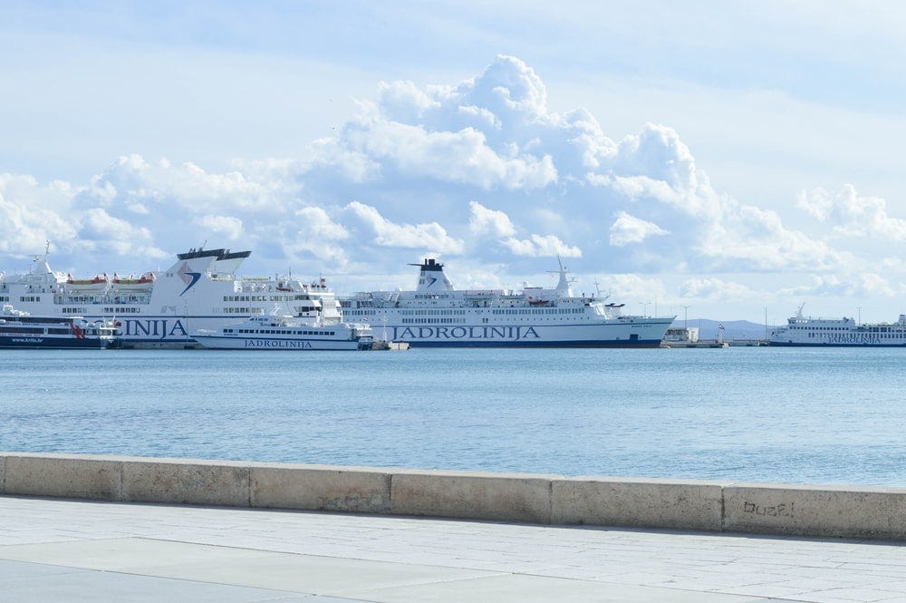 white cruise ship on sea under white clouds and blue sky during daytime