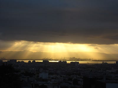 the sun breaks through clouds over the San Francisco Bay looking east from San Francisco