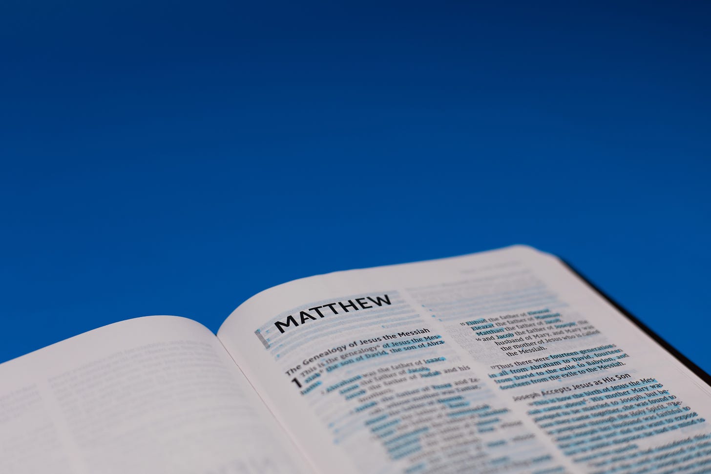 The Bible opened to Matthew against a blue background.