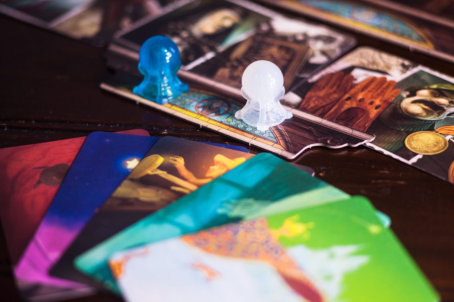 The board game Mysterium being played. Several cards are in front, and the focus is on player tokens.