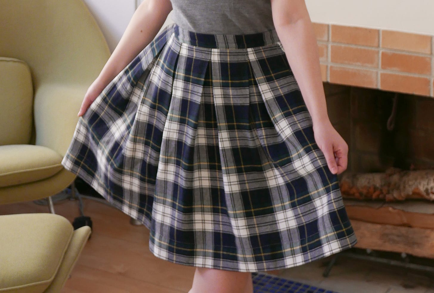 a cropped body shot featuring a blue white and green box pleated skirt