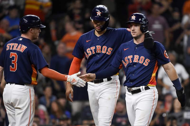 Houston Astros' Alex Bregman, right, celebrates scoring a run with Carlos Correa, center, and Myles Straw (3) during the eighth inning of a baseball game against the Texas Rangers, Sunday, May 16, 2021, in Houston. (AP Photo/Eric Christian Smith)