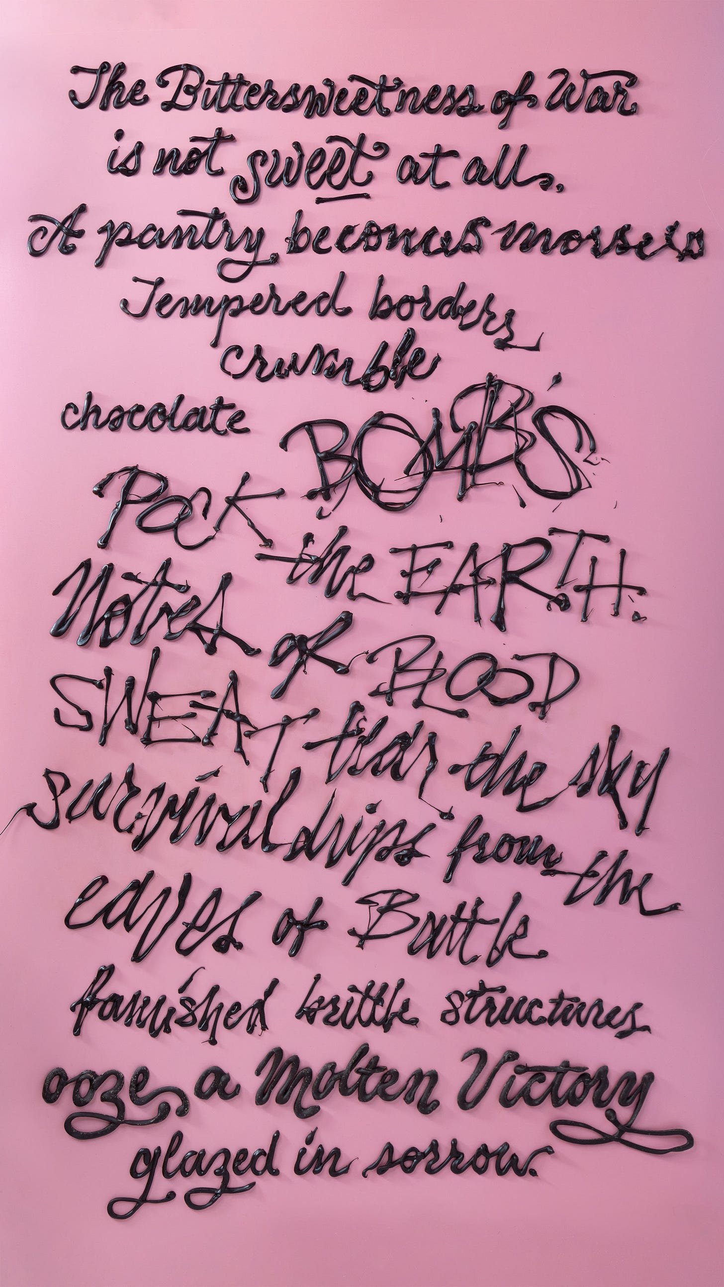 Chocolate words are piped onto a smooth background. In the top right corner is parchment paper with leftover letters and a pair of scissors. It says "The Bittersweetness of War / is not sweet at all. / A pantry becomes morsels / tempered borders crumble / chocolate BOMBS / POCK the EARTH / Notes of BLOOD / SWEAT / tear the sky / survival drips from the / eaves of BATTLE / famished brittle structures / ooze a Molten Victory / glazed in sorrow."