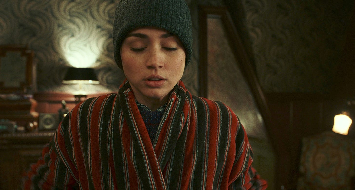 Ana de Armas as Marta Cabrera wearing Harlan's green knitted cap and a striped robe in KNIVES OUT.