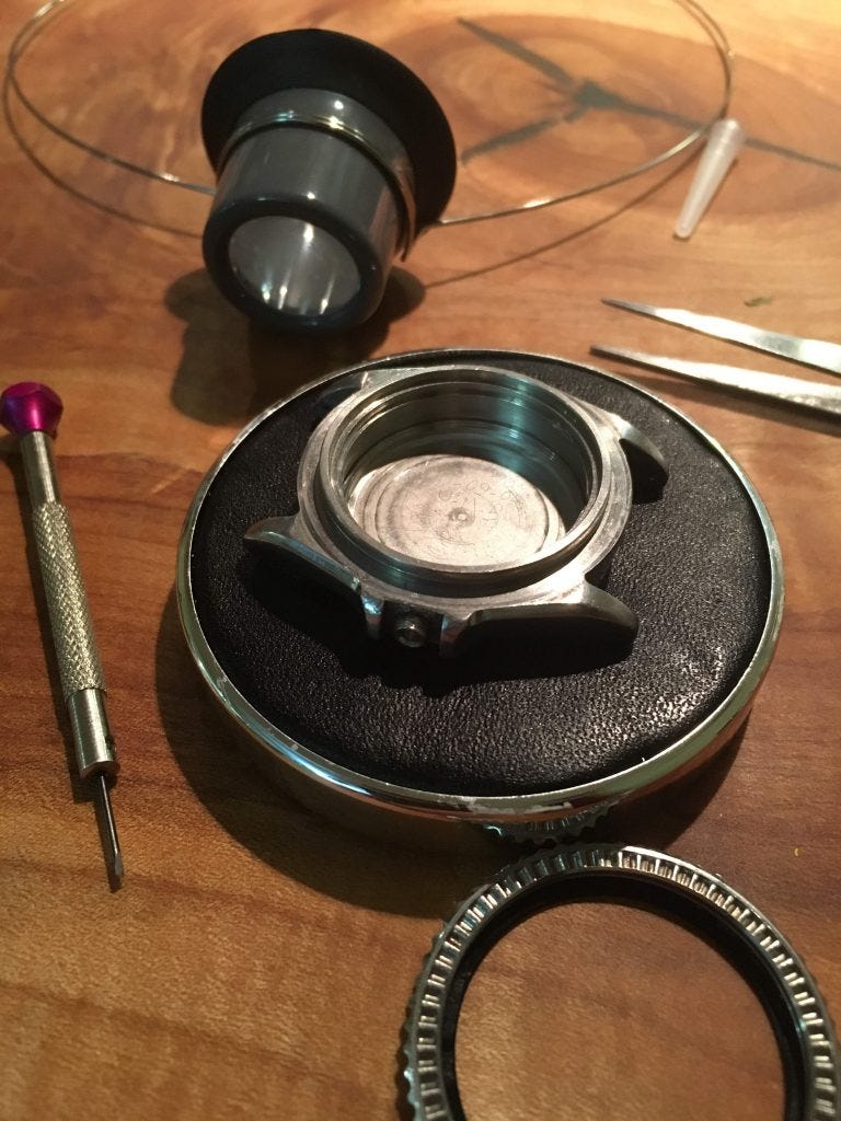 SKX031 case sitting on watchmakers bad with tools around it