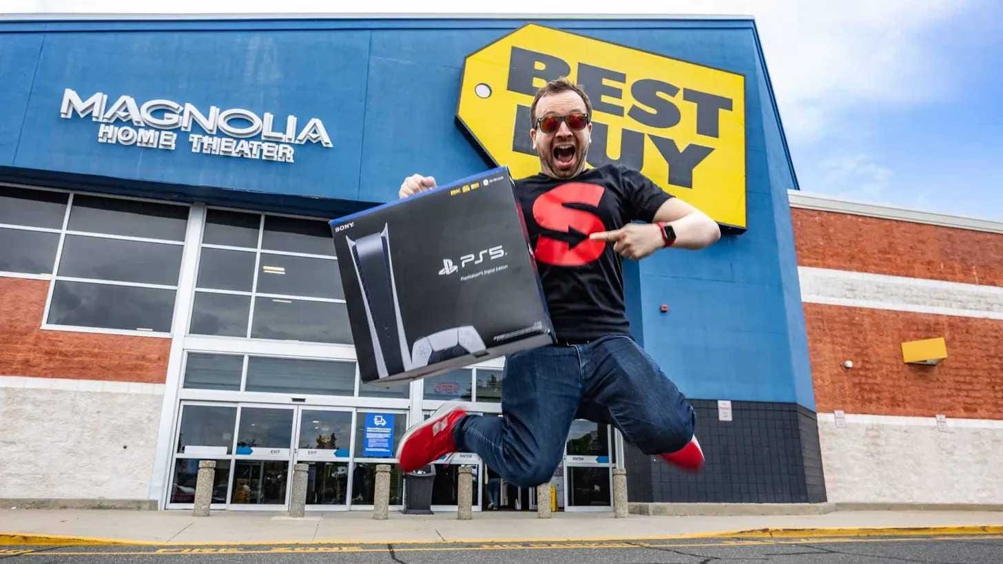 Matt Swider jumping up outside Best Buy holding a PS5