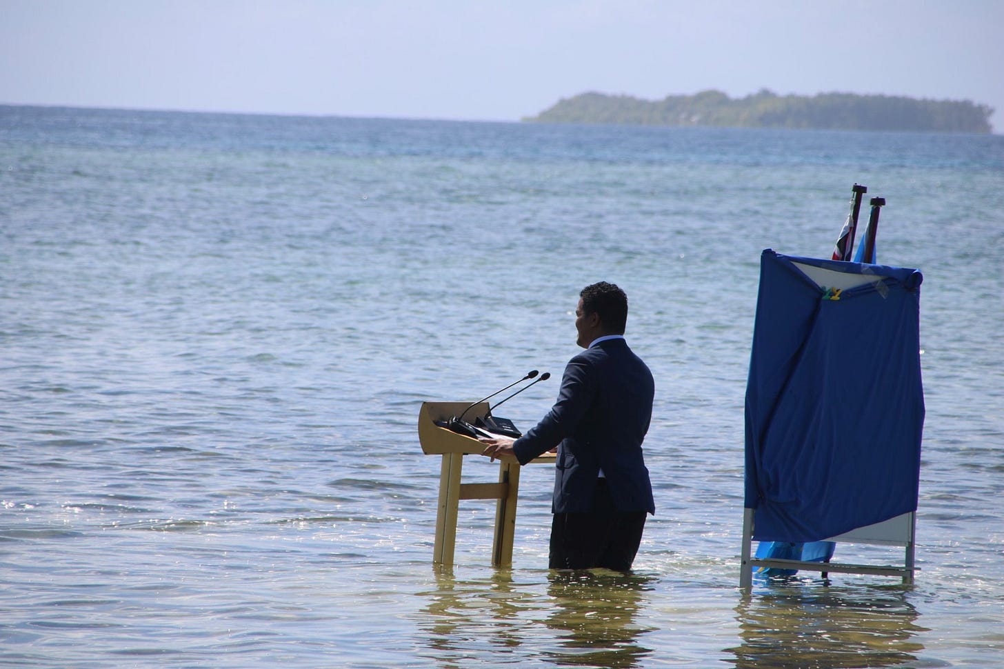 Tuvalu's Minister for Justice, Communication & Foreign Affairs Simon Kofe gives a COP26 statement while standing in the ocean in Funafuti, Tuvalu November 5, 2021. Courtesy Tuvalu's Ministry of Justice, Communication and Foreign Affairs / Social Media via REUTERS 