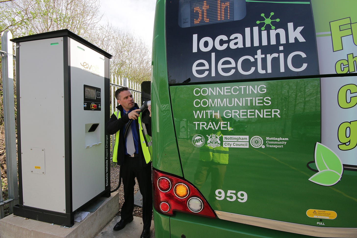 A bus driver charging a green electric bus in Nottingham, UK