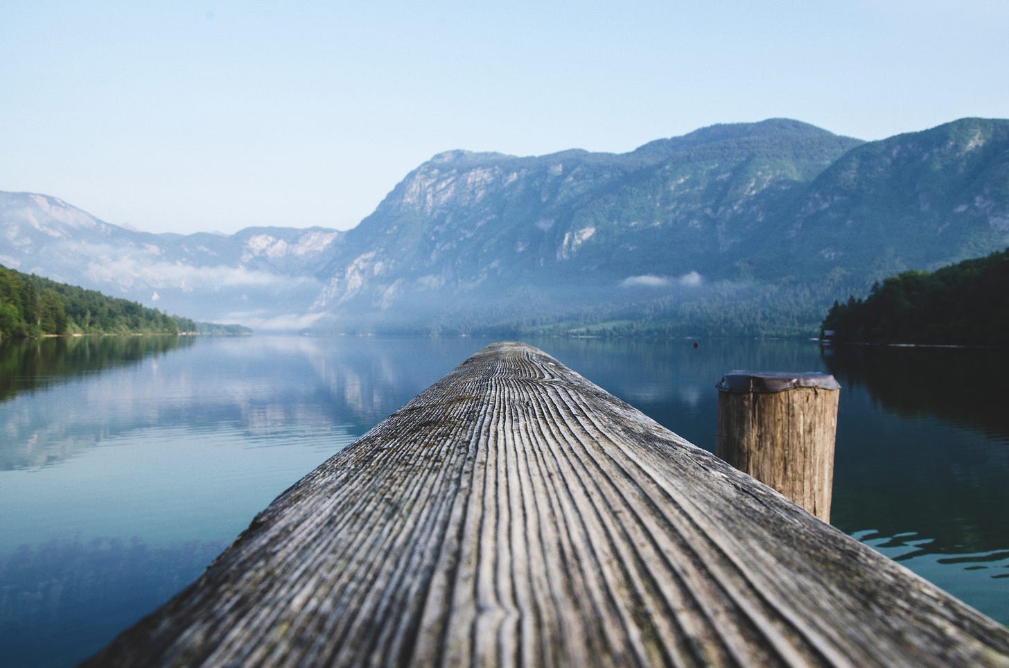 An old wodden plank reaching into a beautiful mountain lake