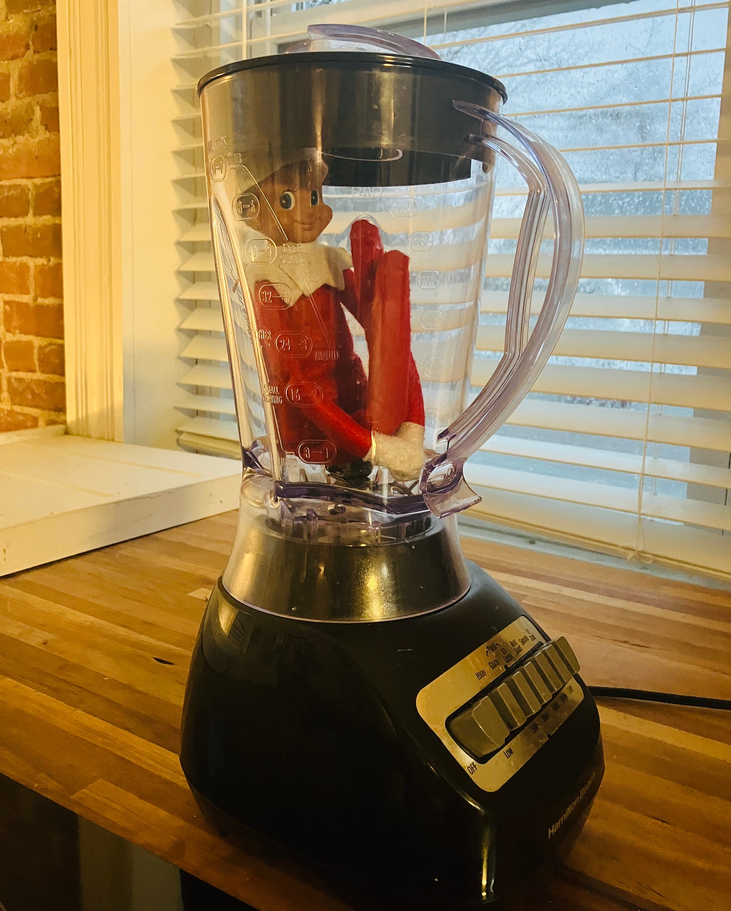 A photo of an Elf On The Shelf in a blender