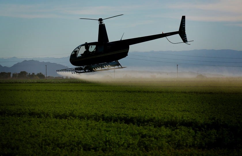 Image of helicopter spraying field.